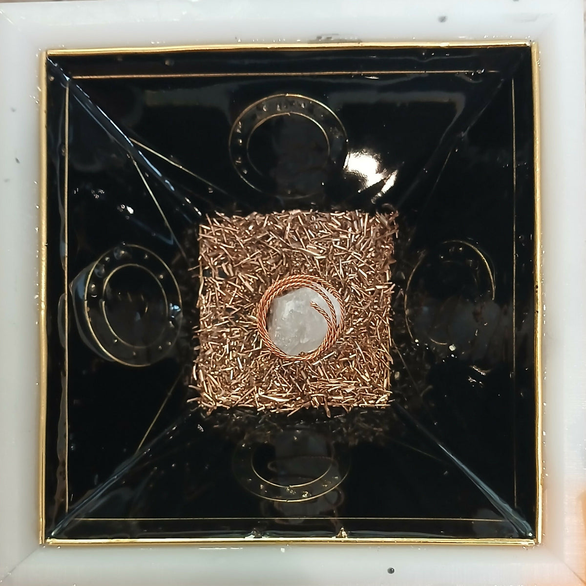 Work in progress: inside the mould, a layer of copper shavings with a clear stone and copper coil in the centre