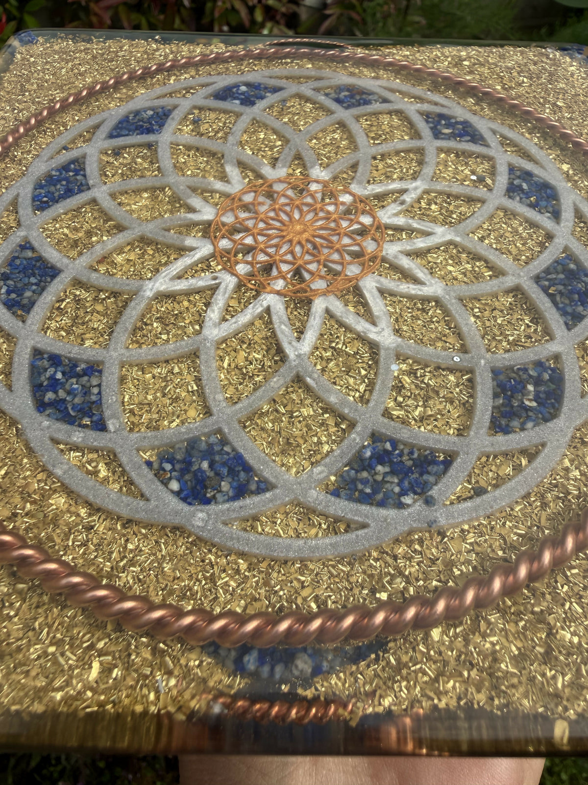 Angled close view of the base Torus design, showing Lapis Lazuli segments, a copper centre and brass flakes under clear resin