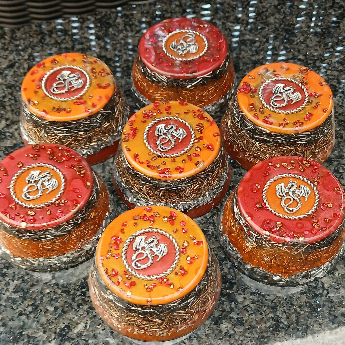 Red and orange dragon towerbusters with silver-coloured dragon motifs and visible metal shavings.