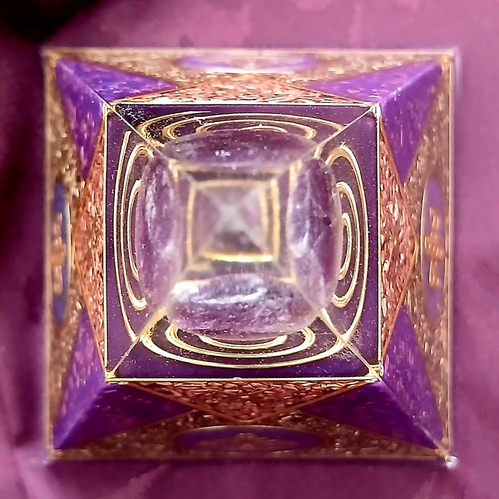Top-down view looking through the clear tip at concentric gold spirals and purple stones