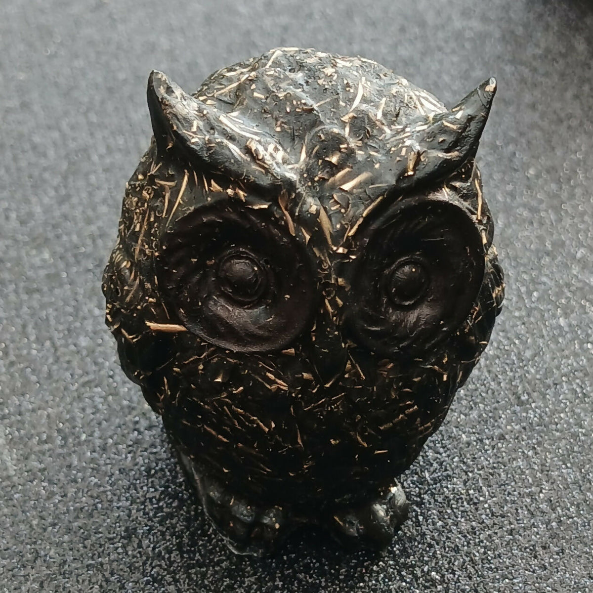 Black owl figure with metal pieces in the resin, front view