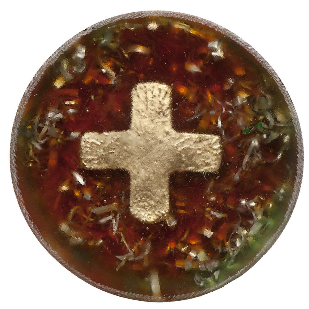 Top view of the round piece with a gold cross set in red-brown resin with metal shavings