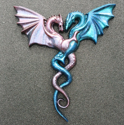 Pink and blue pair of intertwined dragons facing each other with spread wings