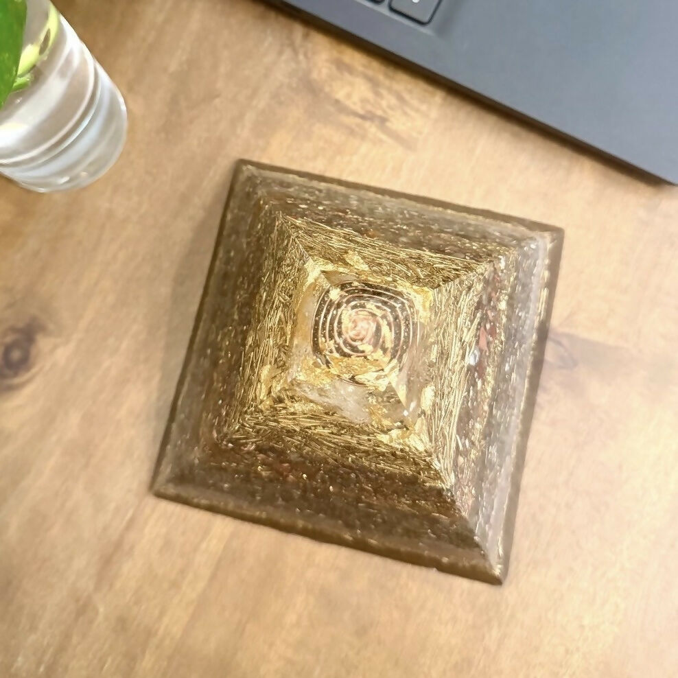 Top-down view of the pyramid on a wooden desk, showing a copper spiral beneath the apex