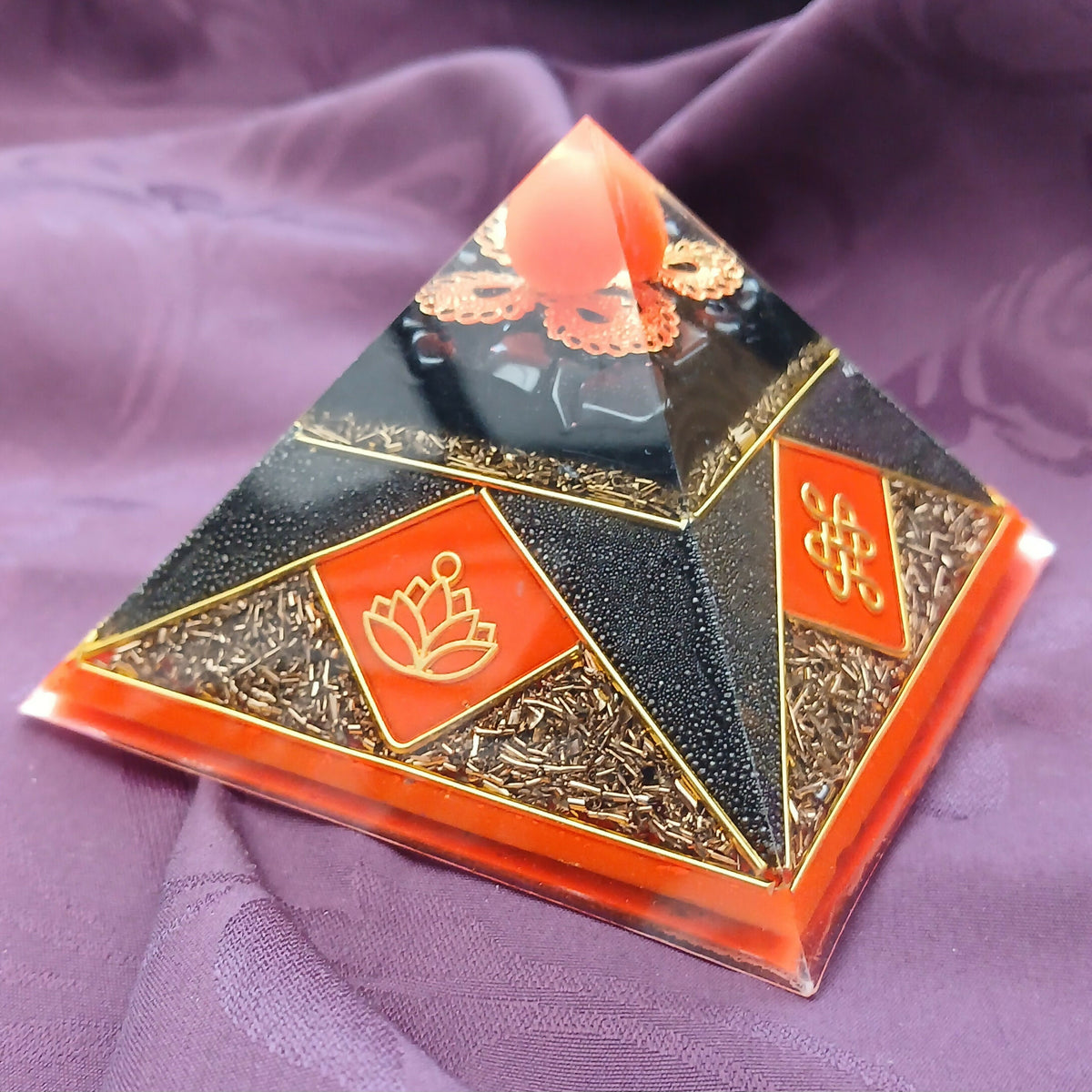 Corner view of the black faces with orange diamond panels, gold lotus symbol and gold flake borders