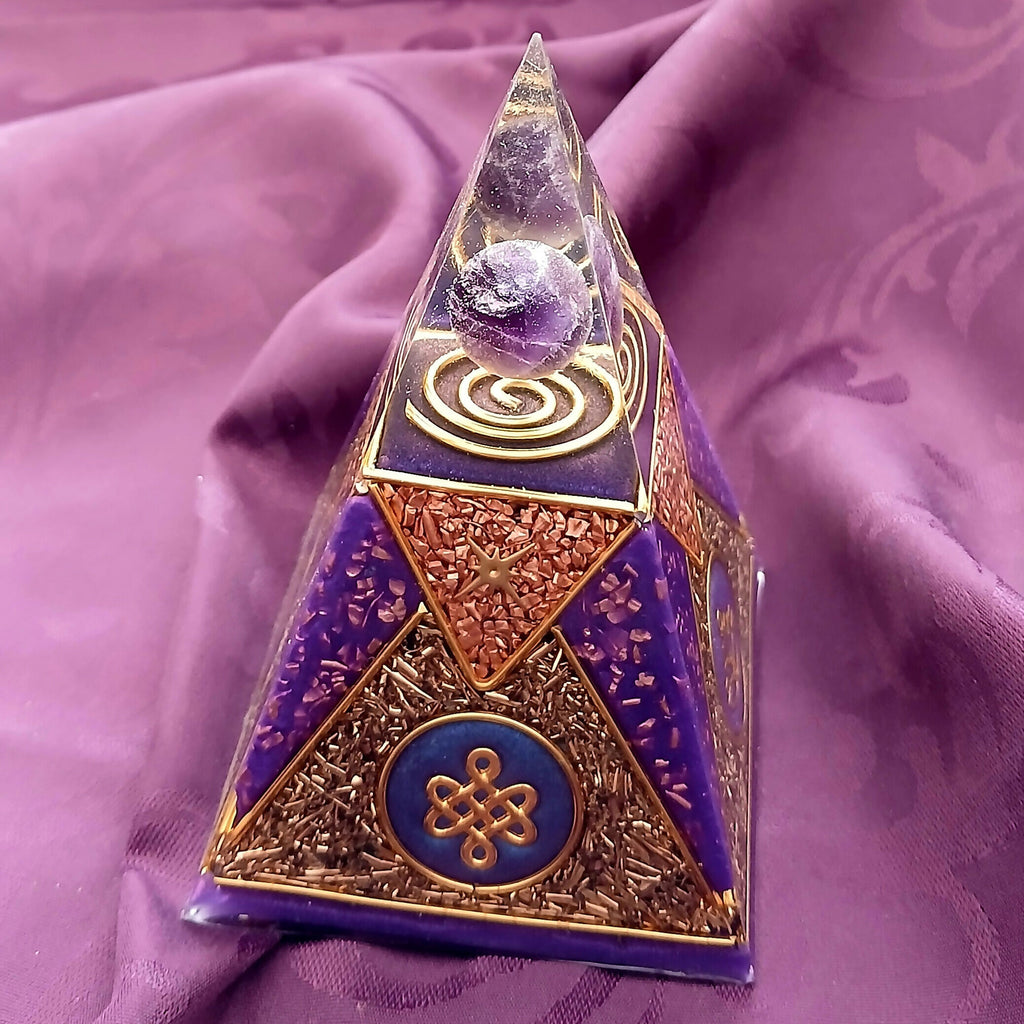 Angled side view showing a gold knot emblem on a blue disc and copper-coloured flake panels between purple triangles
