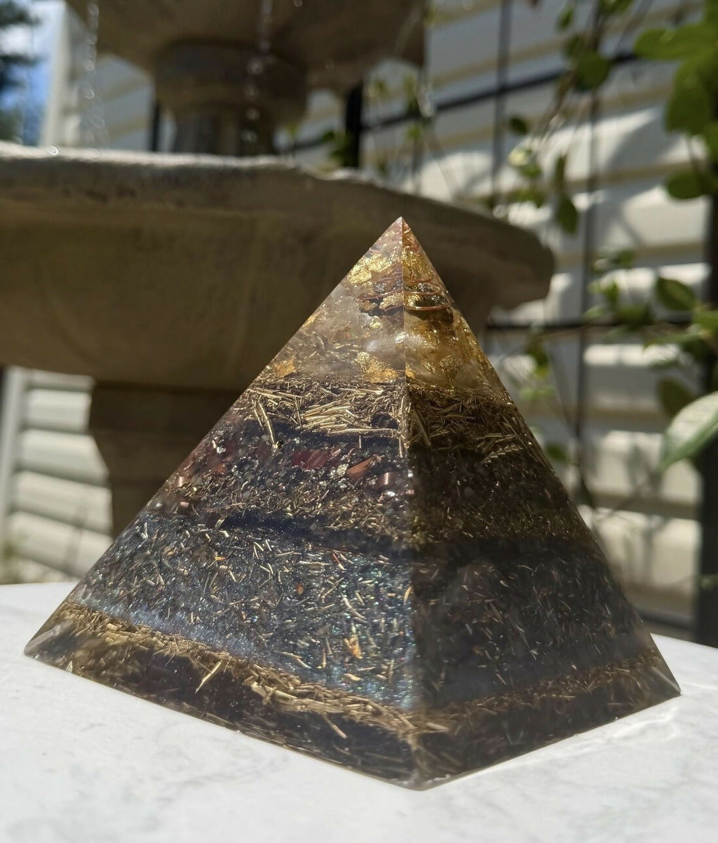 Pyramid outdoors on a white table in front of a stone garden fountain