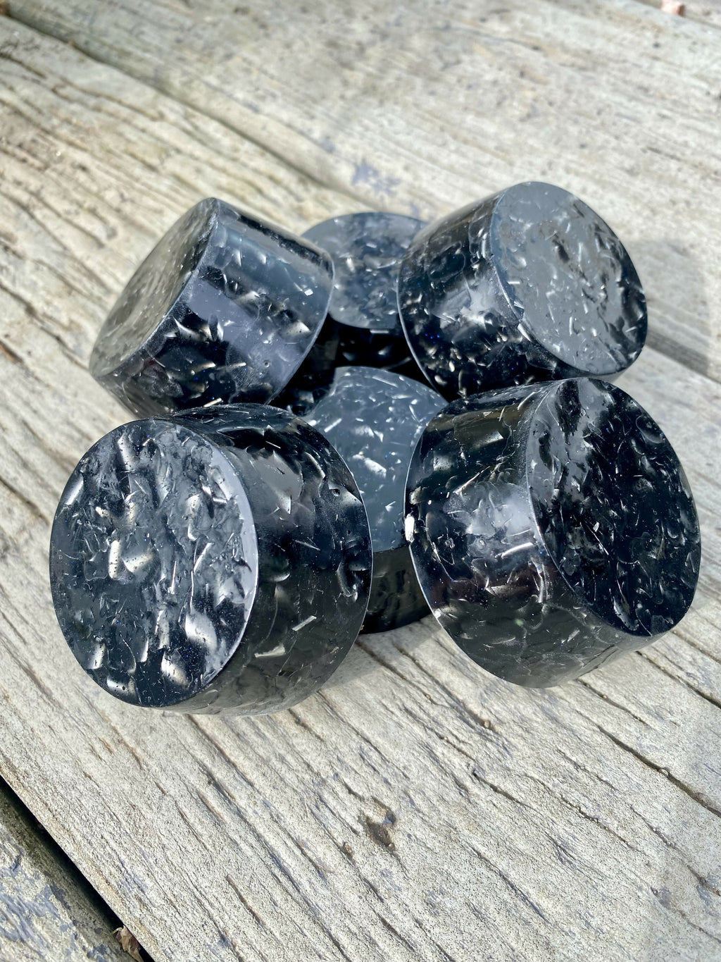 Side view of the black shungite towerbusters showing their rounded edges and flecked surface