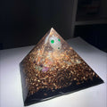 Lil Soul Orgonite Pyramid by Mark Ethan Designs – pyramid with a white sphere with green dots in the clear top, copper and gold shavings and a black base, lit from above