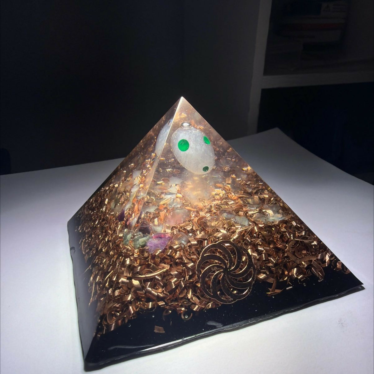Lil Soul Orgonite Pyramid by Mark Ethan Designs – pyramid with a white sphere with green dots in the clear top, copper and gold shavings and a black base, lit from above