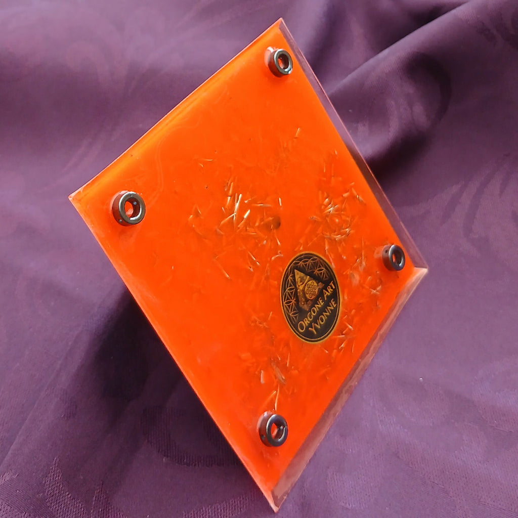 Underside: bright orange base with round metal feet and a dark maker's emblem