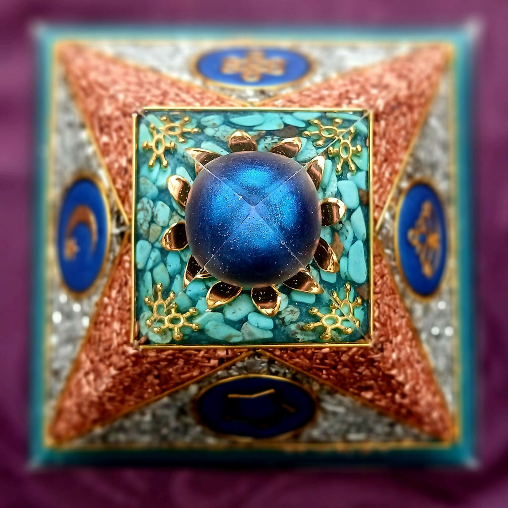 Top-down view of the blue sphere on turquoise chips with gold flower shapes and blue symbol discs on each face