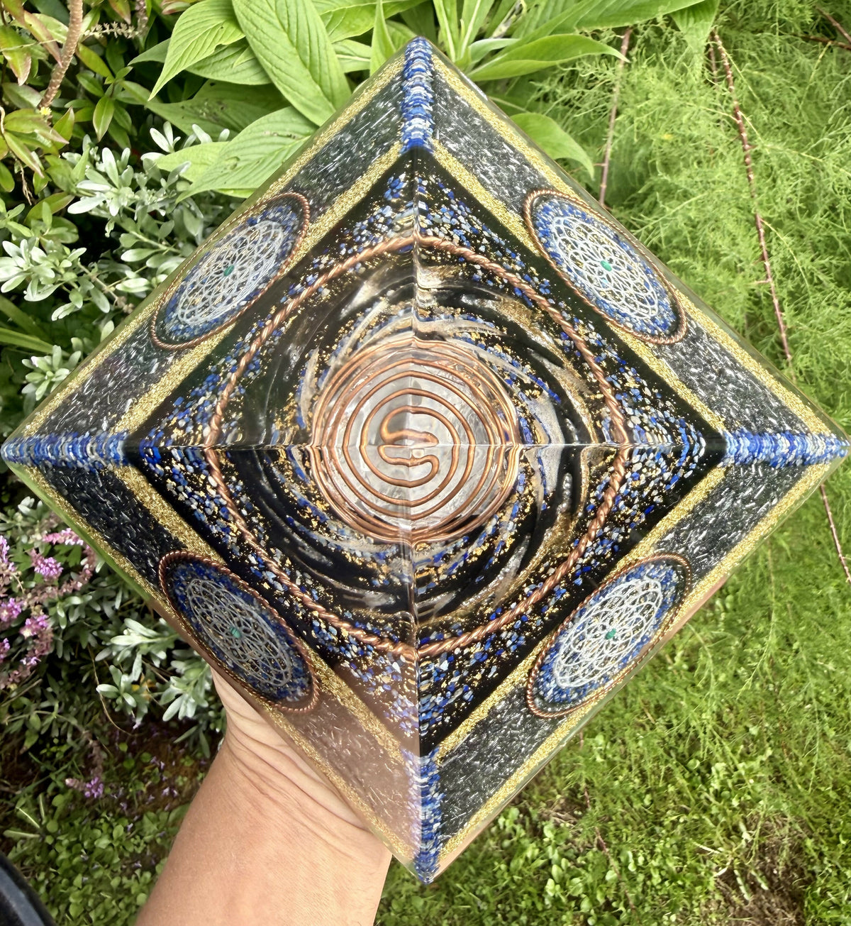 Top-down view of the pyramid held outdoors, with the copper spiral at the centre and Lapis-edged corners