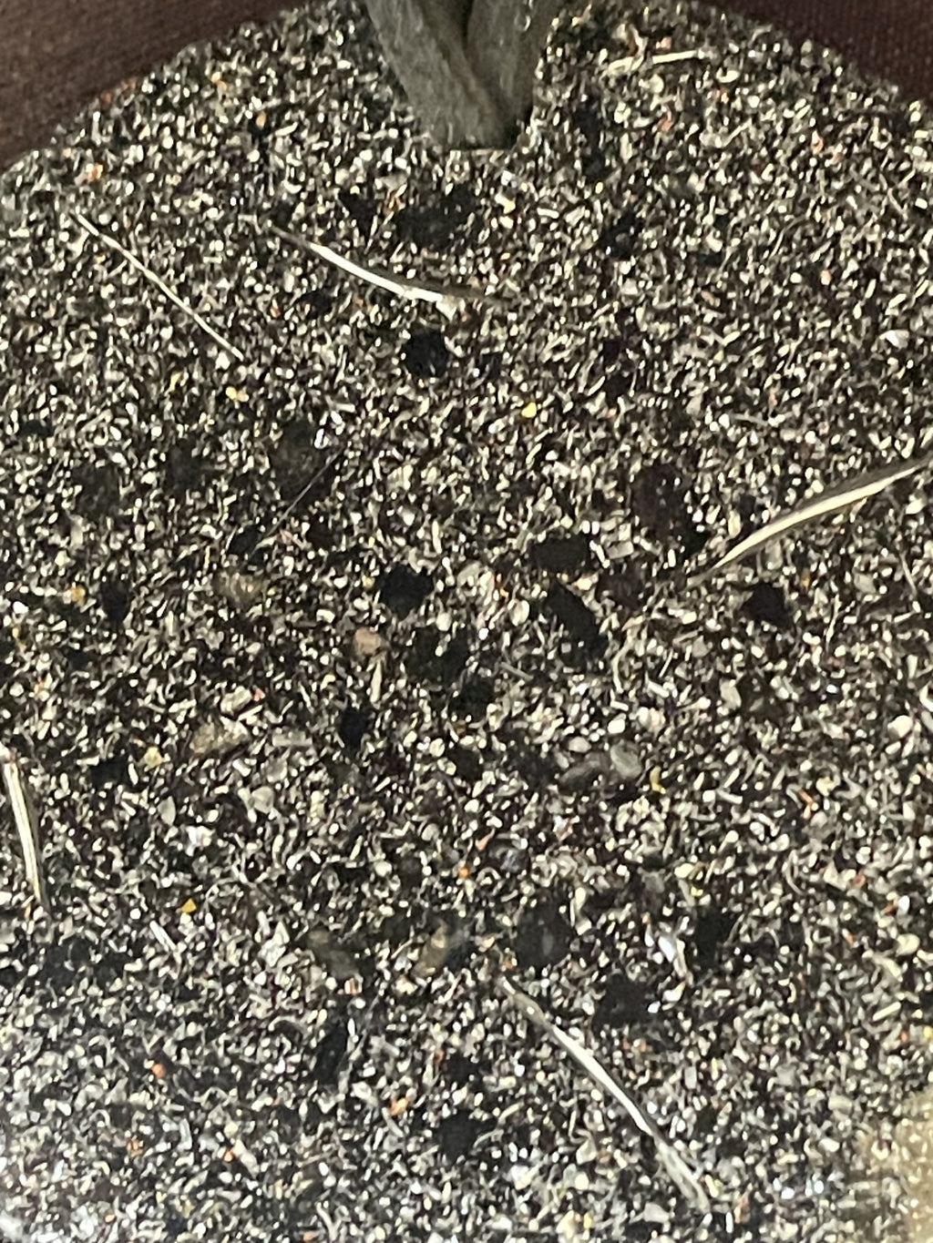 Close-up of the densely flecked grey and silver-coloured reverse of the Silver and Shungite Orgonite Pendant