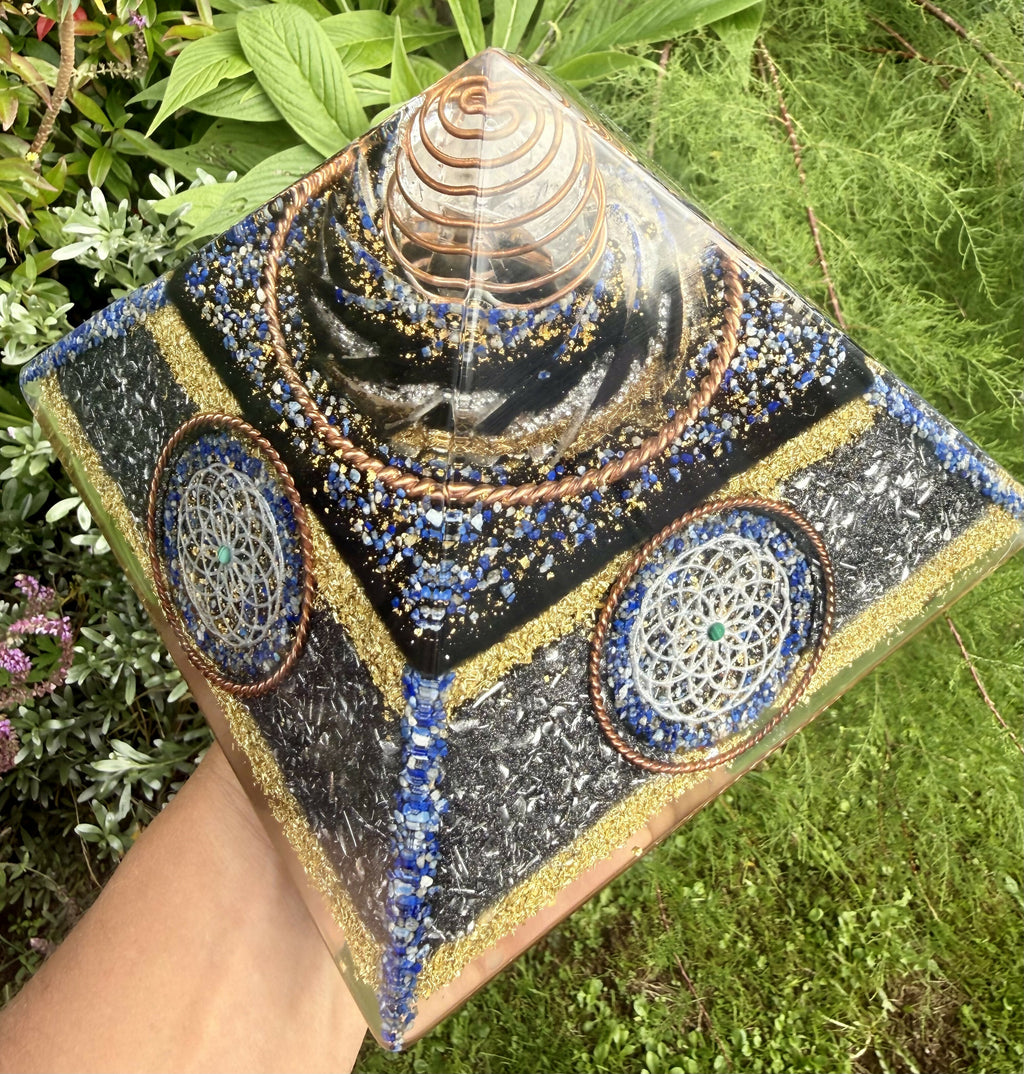 Pyramid held outdoors at an angle, showing two side faces with silver Torus discs and blue Lapis edging