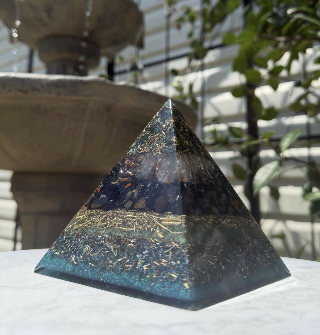 Bloodstone and Kambaba Jasper pyramid by Piezo & Co on an outdoor marble table in front of a stone fountain