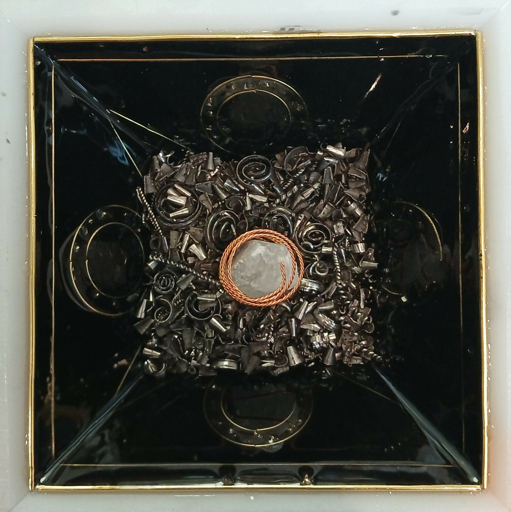 Work in progress: a layer of grey metal pieces around a copper coil inside the black mould