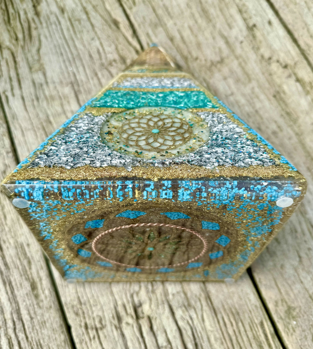Pyramid tilted to show the base edge with a copper coil design ringed by turquoise dots