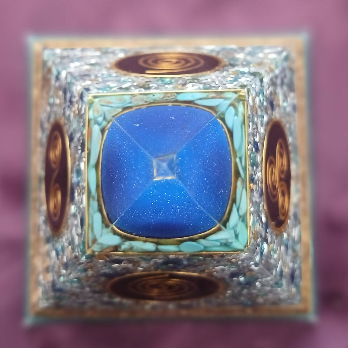 Top-down view of the blue apex sphere with pale blue-green chips and gold spiral discs on each face