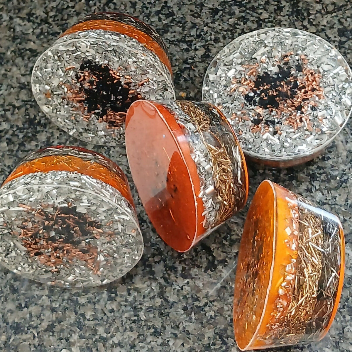Undersides and side views of dragon towerbusters showing metal shavings within clear resin.