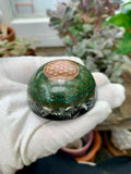 Etched Copper Flower of Life Tower Buster by Mark Ethan Designs – green domed tower buster with an etched copper Flower of Life disc on top and silver shavings at the base, held in a gloved hand