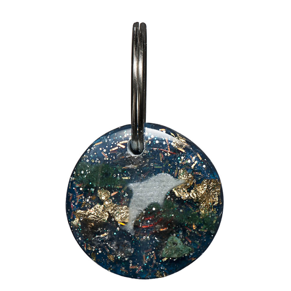 Round dark green Orgone Key Ring with a pale dolphin motif, multicoloured inclusions and a silver-coloured key ring