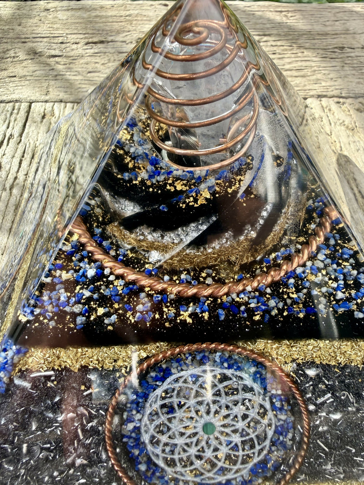 Close view of the clear apex with a copper coil, over layers of Lapis Lazuli chips and a twisted copper ring