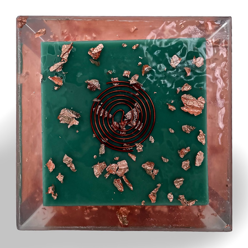 Underside: dark green base with a dark coiled wire spiral and scattered copper flakes
