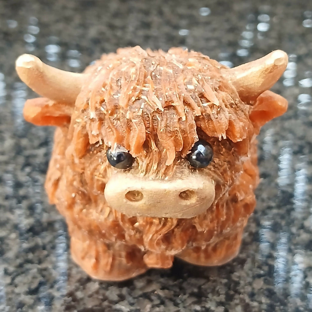 Front view of the brown Highlander Coo figure, with a textured shaggy coat, pale horns and a cream muzzle