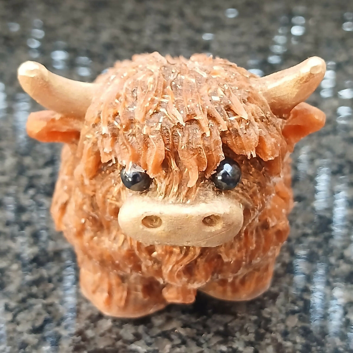 Front view of the brown Highlander Coo figure, with a textured shaggy coat, pale horns and a cream muzzle
