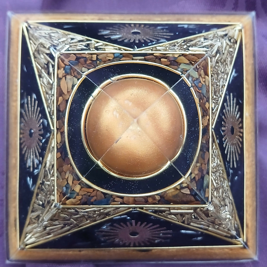Top-down view of the apex sphere framed by brown chips, black panels and gold sunburst designs