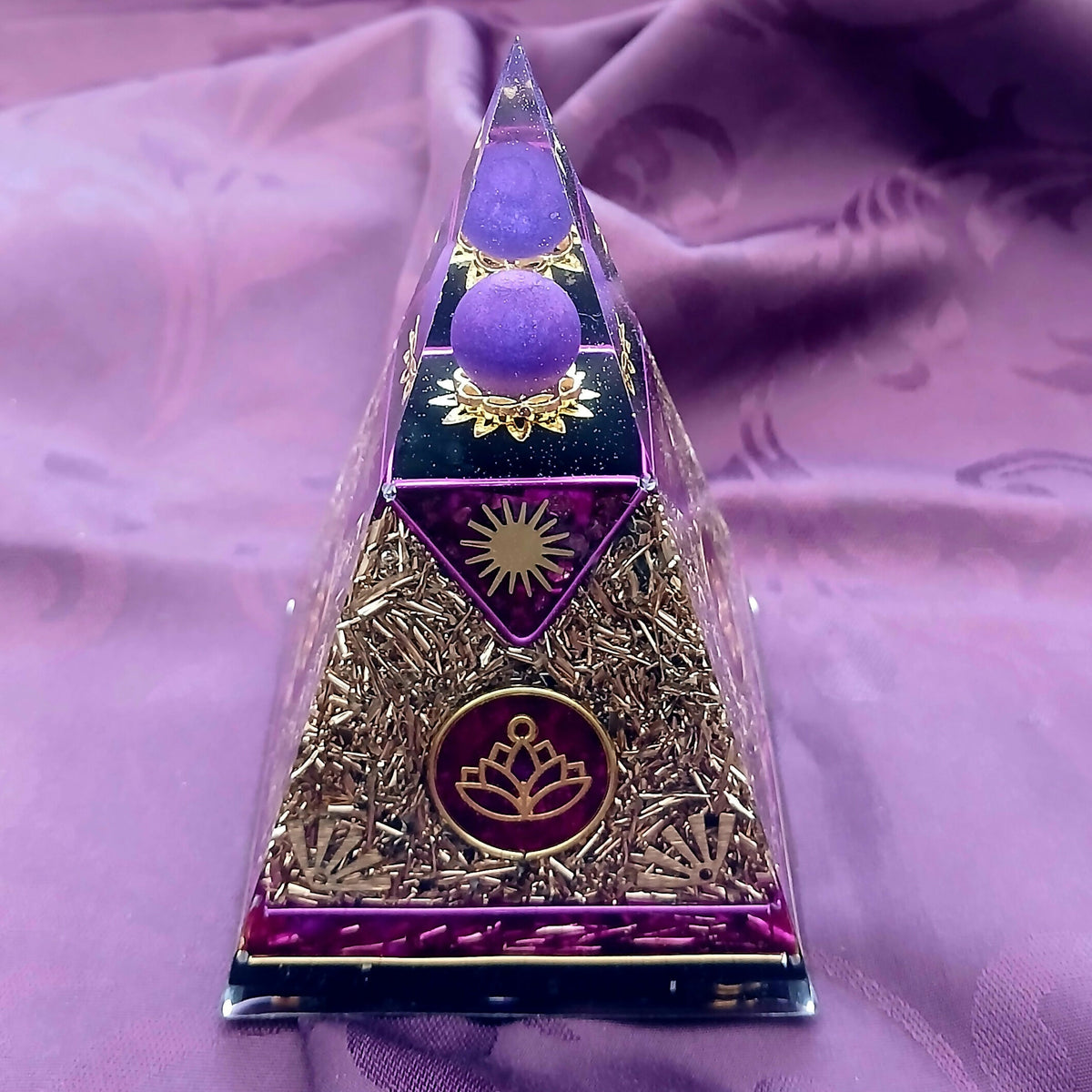 Front face showing the purple sphere, a gold sun motif and a red disc with a gold lotus