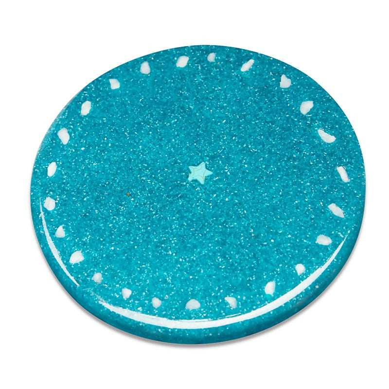 Back of the turquoise plate with small white pieces around the edge and a small star in the centre