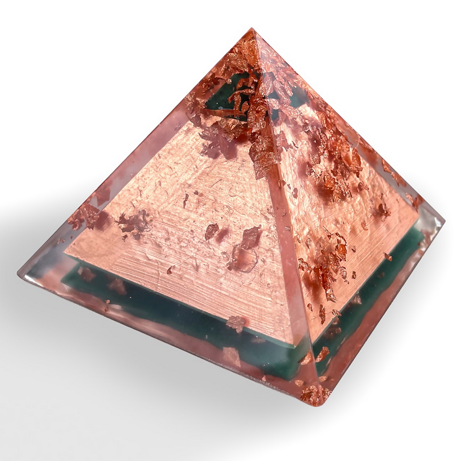 Copper Pyramid by Orgonise Africa – small clear pyramid filled with copper flakes over a dark green base layer, angled side view
