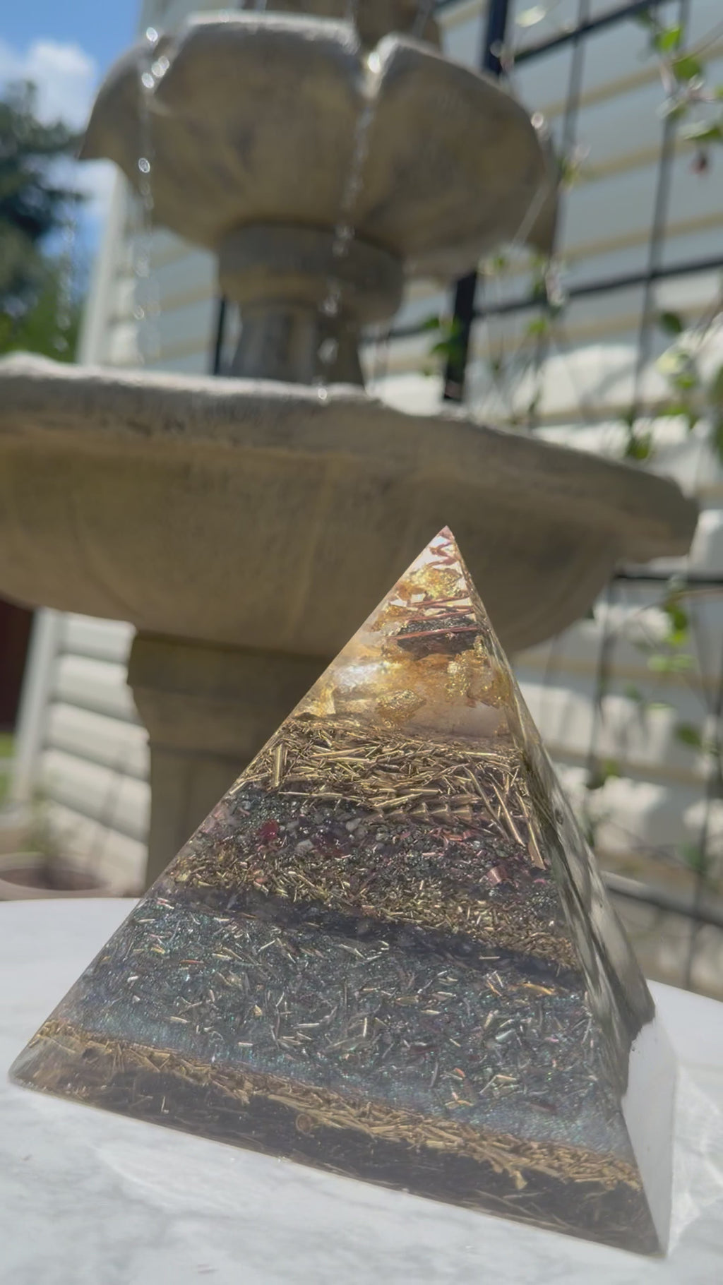 Short video of the Abundance pyramid on an outdoor table beside a garden fountain