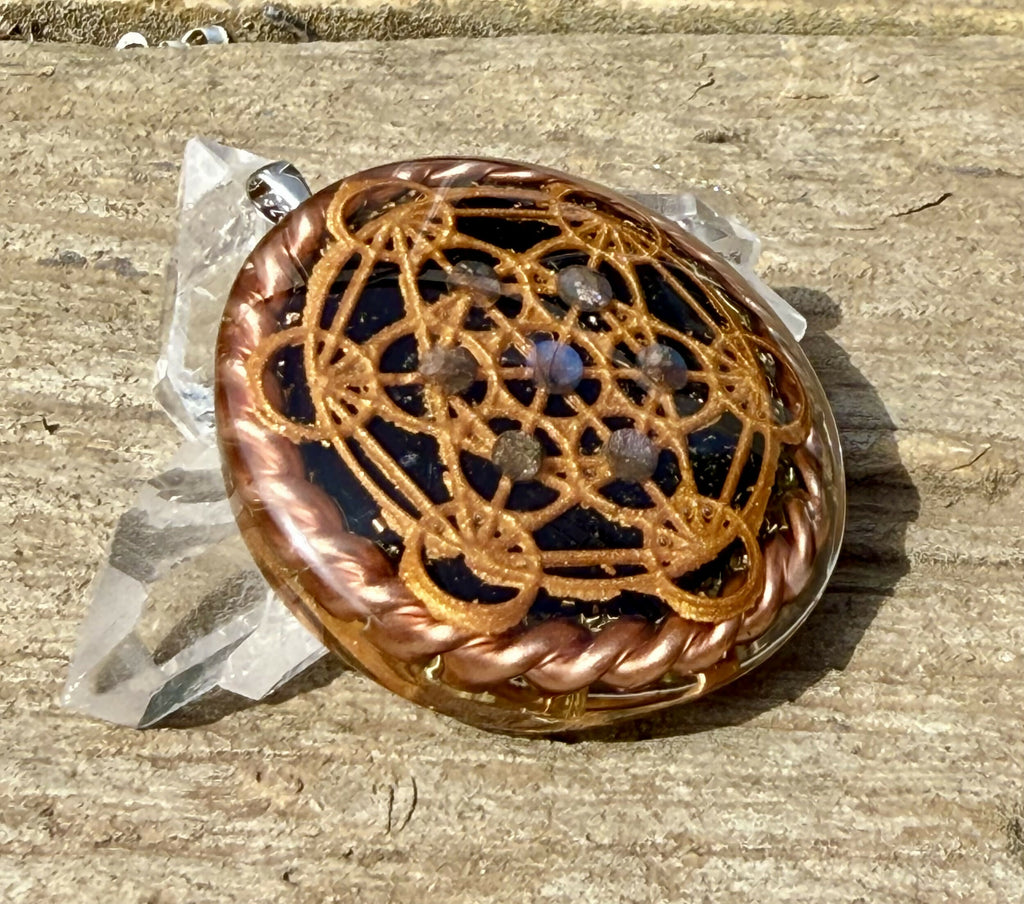 Pendant at a low angle on weathered wood, showing the domed top and twisted copper wire rim