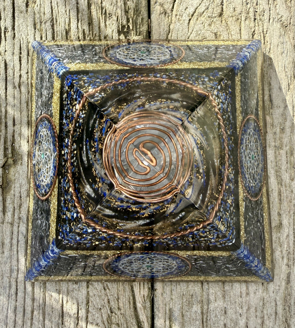 Top-down view of the pyramid on wood, showing the copper spiral at the apex and Torus discs on each side