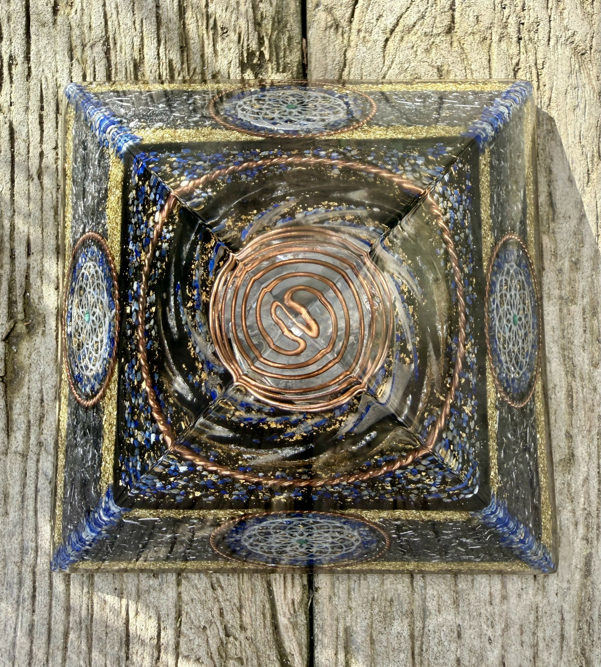 Top-down view of the pyramid on wood, showing the copper spiral at the apex and Torus discs on each side